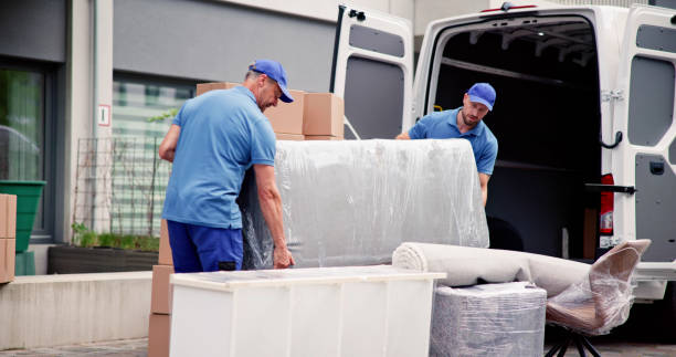 male workers in blue uniform unloading furniture from truck